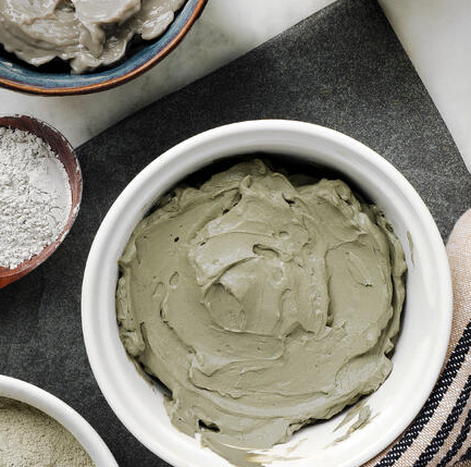 white bowl containing green clay mask